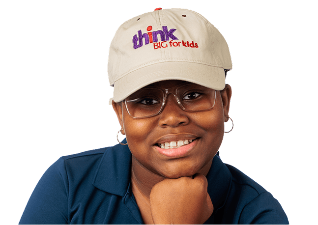 Woman wearing a Think Big for Kids cap smiling at camera